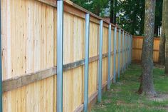 a wooden fence next to a tree in a yard