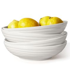 three white bowls filled with lemons sitting on top of each other in front of a white background