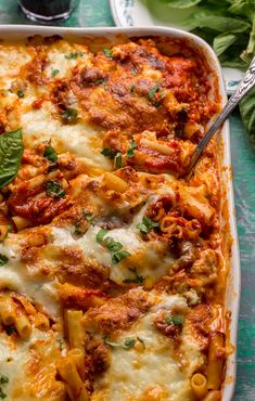 a casserole dish with meat, cheese and sauce in it on a table