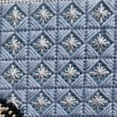 a blue crocheted blanket with white stars on it