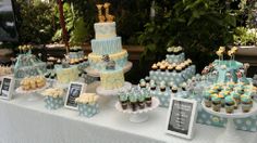 a table topped with lots of cupcakes and cakes