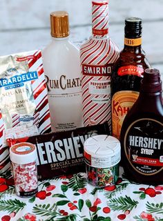 an assortment of liquors and condiments are on a table with candy canes