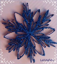 a close up of a blue flower on a white surface