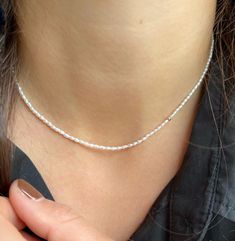 Natural Freshwater Seed Pearl Necklace, 14K Gold Pearl Necklace, Delicate Pearl Necklace, Layering Necklace, Beaded Rice Pearl Necklace, Gift for her, Dainty Beaded Pearl Necklace for Layering ONE IN STOCK READY TO SHIP! A delicate and modern take on the classic string of pearls. This piece will take you from day to night layered up with your favorite gold chains or alone for a simple and sophisticated look.  A beautiful piece of jewelry to celebrate a milestone, birthday, or special occasion. Classic White Beaded Chain Necklace, Fine Jewelry White Round Bead Necklaces, Minimalist Pearl Jewelry With Tiny Beads, White Gold Pearl Necklaces With Round Beads, Dainty Single Strand Jewelry, Dainty White Gold Single Strand Pearl Necklace, Dainty Single Strand Beaded Necklace, Pearl White Beaded Chain Jewelry Gift, Dainty Single Strand Jewelry For Jewelry Making