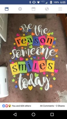 someone wrote this message on the floor in front of their computer screen to say, be the reason someone smiles today