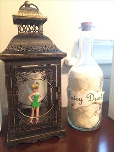 an old fashioned bottle with a tinker doll in it next to a glass jar filled with cotton balls