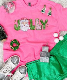 Spread the joy and add a touch of whimsy to your holiday wardrobe with our "Faux Sequin Jolly Santa Graphic Shirt." This festive shirt features a playful graphic design where the word "Jolly" is adorned with a faux sequin Santa face as the 'O,' providing a cheerful and merry look without the actual texture of sequins. Our faux sequin design is not shiny/sparkly. This is a printed graphic design that is meant to give the look of sequins, it is not real sequins. It does look exactly like the photo as this is a printed graphic tee that shows the actual design printed on the tee.
Whether you prefer short sleeves, long sleeves, or a cozy sweatshirt, our "Faux Sequin Jolly Santa Graphic Shirt" offers versatility for various occasions and weather. The graphic sequins are a graphic representation, Playful Graphic Design, Santa Graphic, Jolly Santa, Santa Face, Festival Shirts, Holiday Wardrobe, Cozy Sweatshirts, Graphic Shirt, Family Gatherings