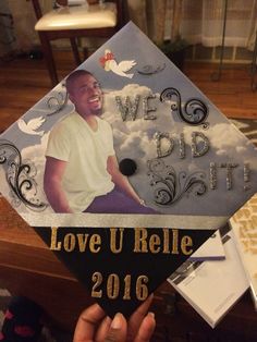 someone is holding up a graduation cap with the image of a smiling man on it