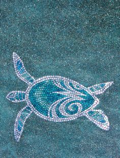 a mosaic turtle on the ground with blue and white tiles