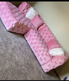 a pink couch sitting on top of a carpet covered floor