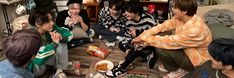 group of people sitting on the floor eating food