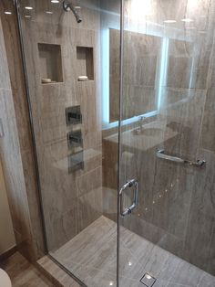 a glass shower door in a bathroom next to a toilet