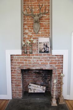 a brick fireplace with a deer head above it