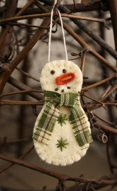 a snowman ornament hanging from a tree