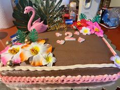 a cake decorated with flowers and a pink flamingo