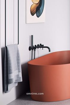 a bath tub sitting next to a painting on the wall in front of a towel rack