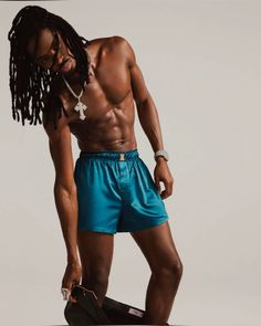 a shirtless man with dreadlocks holding a skateboard