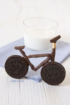 an oreo cookie bike next to a glass of milk