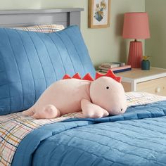 a large stuffed animal laying on top of a blue bed in a child's bedroom