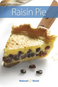 a piece of pie sitting on top of a white plate next to raisins