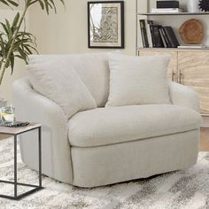 a living room with a white chair and a potted plant on the table in front of it