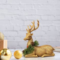 a golden deer figurine sitting on top of a table next to christmas decorations