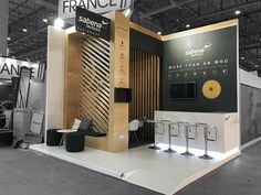 an exhibition stand with chairs and signs on the wall that says francei salon