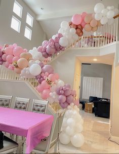 a staircase is decorated with balloons and pink table cloths for an elegant birthday party