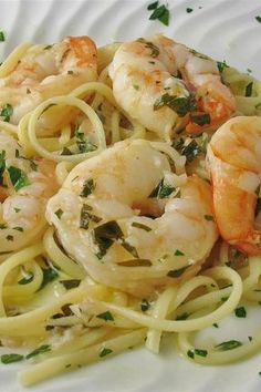 a white plate topped with pasta and shrimp