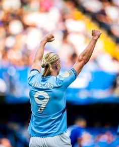 a female soccer player raising her arms in the air