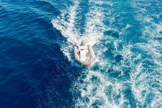 an inflatable boat traveling through the ocean on a sunny day with blue water