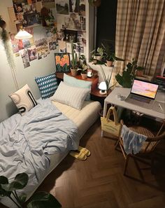 a bedroom with a bed, desk and laptop on it