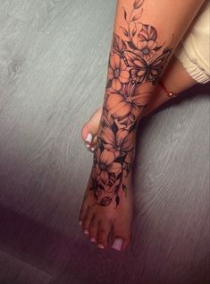 a woman's foot with flowers on it and the bottom part of her leg