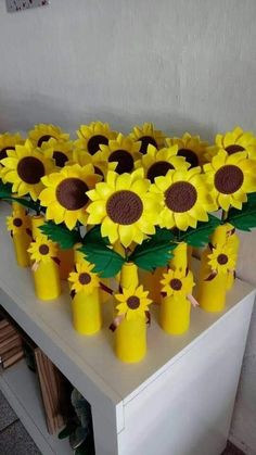 sunflowers are arranged in yellow vases on a table