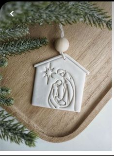 a christmas ornament with a nativity scene in the shape of a house