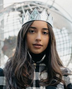 a young woman wearing a silver crown on her head and looking off to the side