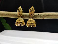 "This Pretty Traditional Pair of Earrings in gold plated Alloy Material. Design: Floral Pattern Color-Gold. Material-Metal/Alloy Size: 2 Inches Long X 1 Inches Wide ( approx.). Obsessed with Indian Jewelry! This is traditional gold-tone jewelry which is carved from our Indian artist. This jewelry are great touch on your collection.  Color may be difference because in few cases color may be different from monitor setting. About Us:  Being of Indian background, has always loved and been inspired b Gold Earrings With Intricate Design For Wedding, Gold-plated Jhumkas For Party, Gold Temple Jewelry Jhumkas For Party, Gold Bridal Earrings With Intricate Design, Gold Bridal Earrings With Intricate Design For Wedding, Gold Jhumkas With Intricate Design For Party, Gold Temple Jewelry Earrings For Marriage, Gold Temple Jewelry Bridal Earrings For Party, Gold Temple Bridal Earrings For Party