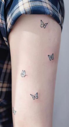 a woman's arm with small butterflies on the back of her left arm, which is black and white