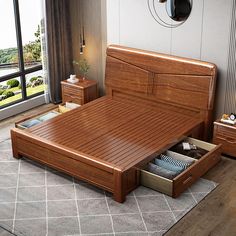 a wooden bed with drawers underneath it in a living room next to a large window