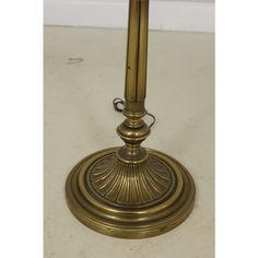 an antique brass table lamp on a white floor