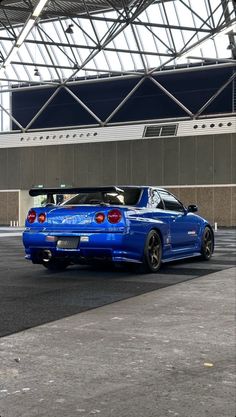 a blue sports car parked in an empty parking lot