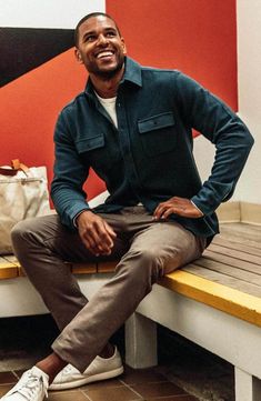 a man sitting on top of a wooden bench