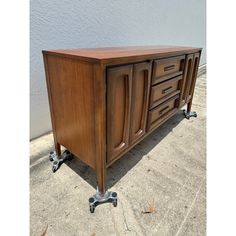 a large wooden cabinet sitting on top of a metal casteor wheel with two drawers