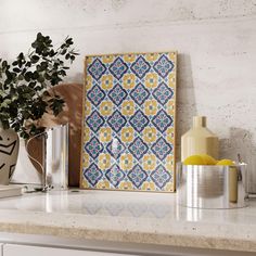 a kitchen counter with a vase, potted plant and an art work on the wall