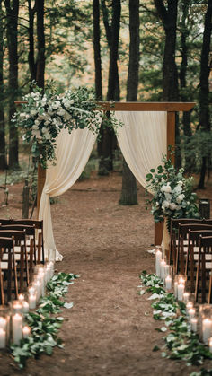 A forest wedding scene with a lace-draped wooden structure in the background with guest seating to the side of the aisleway. Candlelights and flowers create an intimate setting. Diy Wedding Backyard, Outside Farm Wedding Ideas, Boho Wedding Outside, Rustic Venue Wedding, Country Sage Green Wedding, Rustic Wedding Decor Colors, Rainy Day Wedding Ideas, Wedding Ideas Forest Theme, Wedding In Backyard Ideas