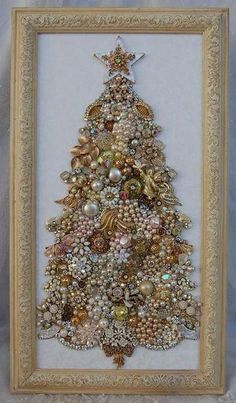 a christmas tree made out of beads and other items in a frame on a table