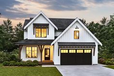 a white and black house with two garages