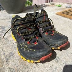 a pair of black and yellow shoes sitting on the ground