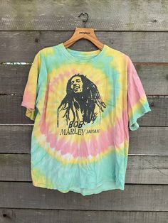 Nicely worn in Bob Marley t-shirt. Classic with a Rasta tie dye. A couple small holes throughout.  Size large Measurements: Sleeve: 7 inches Shoulders: 22 inches Chest: 22 inches Hem: 24 inches Length: 26.5 inches //Policies// We ship out 3-5 days after your purchase. Buyer is responsible for all import fees and duties their individual country applies. All items have been examined and any flaws will be noted in the description. No returns unless items are misrepresented. Measurements are taken f Vintage Tie Dye Washed T-shirt, Vintage Washed Tie-dye T-shirt, Casual Green Festival T-shirt, Vintage Distressed Tie Dye T-shirt, Vintage Tie Dye T-shirt For Summer, Acid Wash Crew Neck T-shirt With Hippie Style, Bleached Multicolor Graphic Tee, Vintage Tie Dye Hand Dyed T-shirt, Acid Wash Cotton Hippie T-shirt