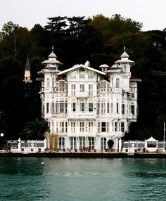 a large white house sitting on top of a lake